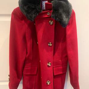 En röd kappa med en fantastisk päls (inte äkta). Skick är nästan som helt ny 