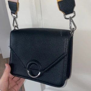 Väska  -  Fin svart väska, Man kan vrida bandet och då blir det gult och sen kan man vidare igen och då blir det ljus rosa❤️🌷köpte på typ H&m 