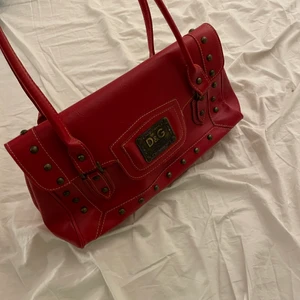 Röd väska från d&g - riktigt snygg vintage väska. säljer pga ingen användning. passar riktigt bra till läderjackor men också sommaren. rymmer även mycket. bjuder på frakt vid snabb affär<3