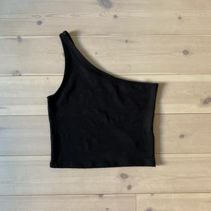 One shoulder topp - Croppat one shoulder topp/linne från Gina tricot. Sitter supersnyggt men säljer pga inte min stil längre!