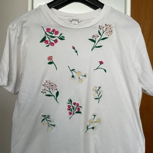 Fin vårig/somrig tshirt från Monki!! - Söt tshirt med sydda blommor på. Mycket fin och fräsh !! 