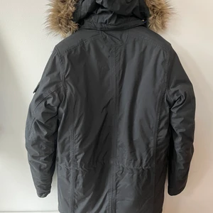 Ny vinterjacka från Tenson - Oanvänd varm vinterjacka från Tenson med avtagbar luva, längre modell, dragsko i midjan, strl S. Nypris 1990:-