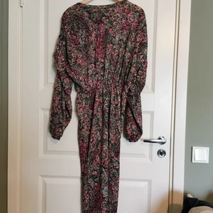 Glittrig klänning med snyggt mönster - Cool klänning från Zara. Lite påfågelaktigt mönster och snygga detaljer på ärmarna. Sitter åt på underdelen och mer luftig på överdelen. 