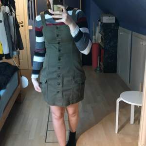 Militärgrön klänning med fickor, snygg och formpassande. Oanvänd