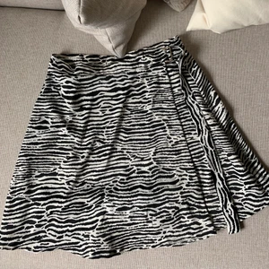 Satinkjol i zebra mönster  - Satinkjol i zebra mönster från H&M, storlek 38. Från början var kjolen lång men har fått den uppsydd. As ball kjol till sommaren! Buda i kommentarerna
