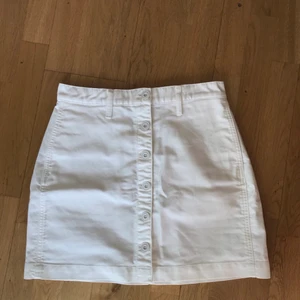 Vit kjol - HELT OANVÄND vit kjol med knappar framtill från uniqlo. Riktigt skönt och stabilt material. Den är tyvärr för stor i midjan för mig. Står ingen storlek men står waistline 68,5 cm. 