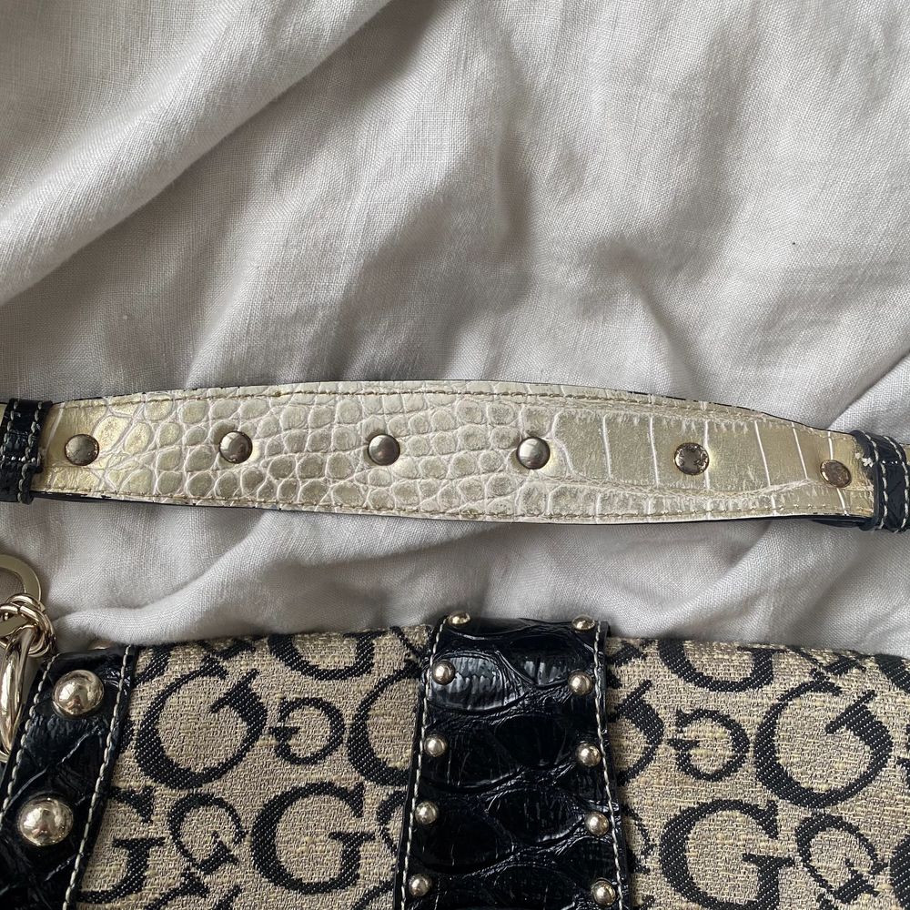 FINNS ANNONSEN KVAR FINNS VÄSKAN KVAR⭐️ Skitsnygg lagom stor Guessväska i jättefint skick! Medkommer dustbag. Feta detaljer som tex nitar! Det är typ en lite mer subtle guldfärg vilket e supersnyggt! Ända noteringen är på undersidan av handtaget där man kan se lite spår av användning. Men inget man lägger märke till! Skriv privat för fler bilder och ifall fler är intresserade blir det budgivning!🌸. Väskor.
