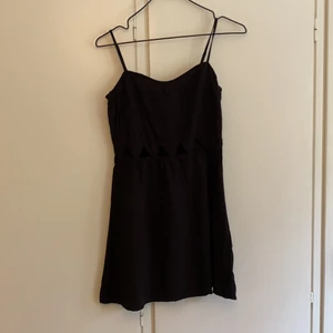 Svart klänning med utskurna trianglar  - Perfekt klänning att dra över bikinin i sommar! Ganska kort och hade därmed rekommenderat den till någon lite yngre. 