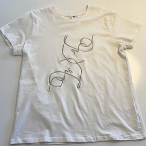 T-shirt  - Vit t-shirt med två beigea ansikten på från MQs märke visual clothing project som utgått. Om flera t-shirts eller annat vill köpas så slås frakten ihop till en istället för flera olika. 