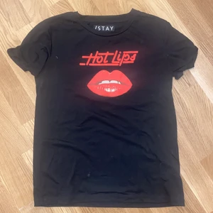 Svart T-shirt med tryck - Snygg svart T-shirt med rött tryck. Storlek S. Knappt använd!