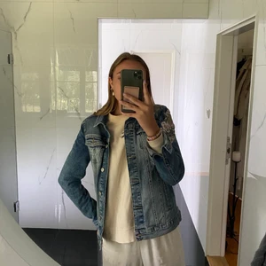 jeansjacka  - blå jeansjacka som säljes pga den ej används. Blommigt broderi på ena axeln. Stl xs men är lite mer som S. Jag är ca 172cm lång. Köparen står för frakten