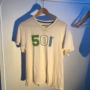 En vit/grön/blå vintage t-shirt från Levi’s 501 i storlek xsmall/small.  Trycket är på framsidan.