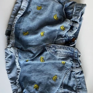 Jeans shorts med bananer på  - Jeans shorts med bananer på fram och baksida. Passar inte mig längre. Köpte den från Asien, så storleken är mindre. På byxorna är det XL men skulle chansa på medium eller liten large! Jag står ej för postens slarv och skickar med postnord:) 