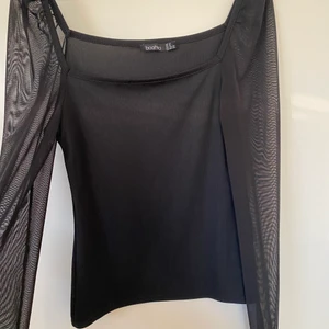 Svart ribbad topp med mesh-ärmar - Strl 38/40