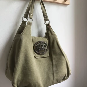 Väska - En grön, beige väska i bra skick. Med ett super coolt spänne! 