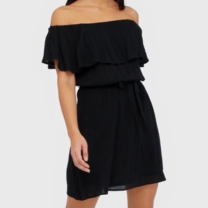 Svart sommarklänning - Jättefin svart sommarklänning i off shoulder modell från Nelly. Köptes förra sommaren men kom tyvärr aldrig till användning. Superskönt tyg och finns ett knytband i midjan som går att ta bort. Storlek 36