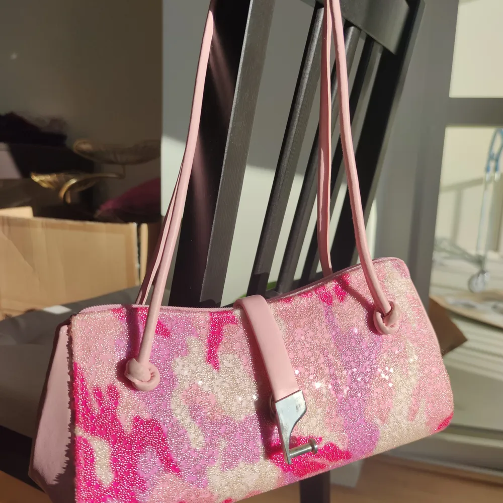 En jättegullig och fin rosa axelväska som har en unik design. Den är läder överallt förutom framsidan som är gjord av strass. Den är använd bara en gång så den är som ny. Skriv om ni vill ha fler bilder🥰. Väskor.