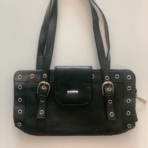 Svart axelväska - Snygg och trendig axelväska med coola detaljer! Köpt hos en skräddare i Stockholm och aldrig använd