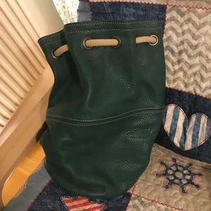 Green leather bucket bag - Never worn leather medium bucket bag with two sraps. Can be worn as a sholder bag, crossbody or as a backpack. 