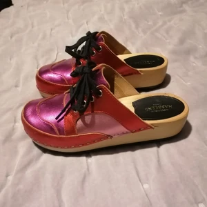 Swedish hasbeens. Strl 37 - Sneakers clogs/ träskor  från Swedish Hasbeens. Strl 37. Endast använda ute en kort stund. Så fina i rosa/röd metallic läder. 