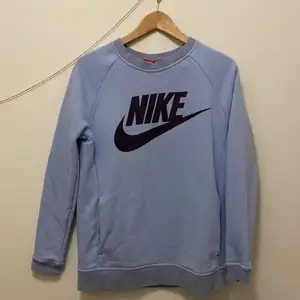 Ljusblå Nike sweatshirt med mörkblått Nike tryck, Storlek S.