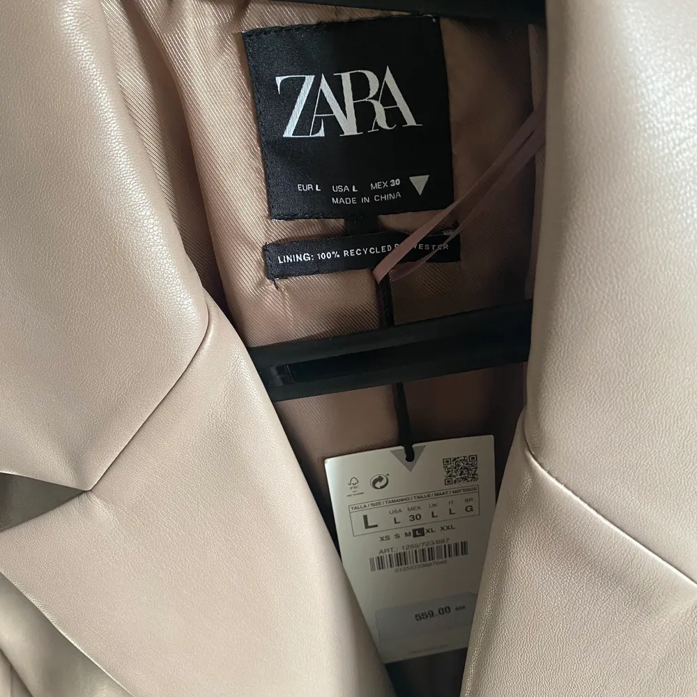 En syntetisk läder blazer från Zara i en ”dusty pink/brown” färg. Färgen är lite svår att få på bild. Helt ny/oanvänd i storlek L. Denna skulle passa en storlek M om man vill ha en oversize fit. Nypris 559:-. Jackor.