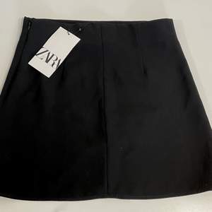 En svart Zara kjol i med slits. Är aldrig använd, prislappen finns kvar. Den är i storlek XS.  Frakten ingår ej i priset. 
