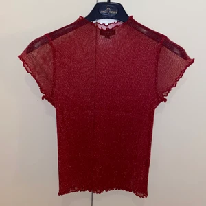 Röd glittrig meshtop - Glittrig meshtop från TopShop. Liten i storlek men väldigt strechig. Använt väldigt lite, 2-3 gånger. 