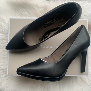 Tamaris klassiska pumps. Strl 38 - Super fina pumps i tidlös modell och matt svart färg 🖤  De är helt oanvända (kan tyvärr inte använda klackskor längre) men är bekväma även för mig. Nypris är 599, skickar med kartong och allting. Köparen står för frakten eller så kan vi mötas i Sthlm 🧚🏼‍♀️