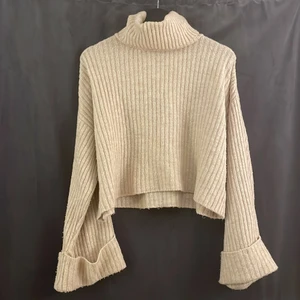 Bergige stickad tröja från Gina Tricot - Beige stickad tröja från Gina tricot i storlek XS men passar som en Small. Vida ärmar och hög krage.