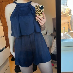 Mörkblå byxdress  - En kort byxdress i silkesmaterial, jättefin till sommaren. Knytning i ryggen 