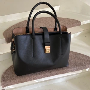 Svart damväska  - Svart damväska från HM med axelrem. Obefintligt använd. 