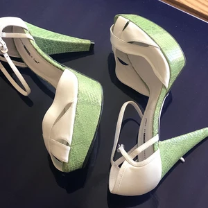 Klackskor storlek 40 - Vita klackskor från sixteen minutes of fame. Storlek 40 och aldrig använda. Gjort av vitt läder med grönt ormskinn på klacken osv, svart sula.