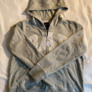 GAP Tröja - Säljer denna luvtröja med dragkedja från GAP. Texten står skriven med små diamanter💎 alla diamanter sitter kvar🦋