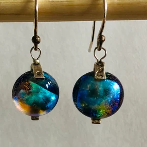 Opalfärgade örhängen i glas och silver  - Supersnygga handgjorda örhängen i opalliknande glas, med band i silver som håller glaset. Örkrokar i 925 silver. Glasen är ca 1,2 cm i diameter.