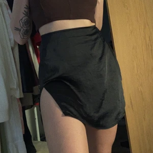 Svart minikjol  - Svart minikjol i stretchigt silkesmaterial från motelrocks! Nyskick! Passar S/M, säljes för 130 kr exklusive frakt 🌺