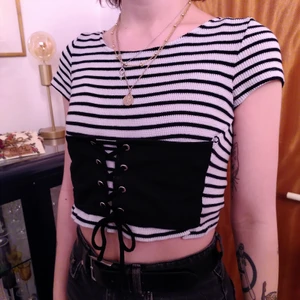 Topp med korsett - Tight elastisk topp med korsettdel som jag sytt till själv. Jag säljer den för att jag fortsätter envisas med att köpa randiga plagg även när jag inte gillar det.   (Tredje bilden visar en skada som jag kommer laga när du köper plagget.)