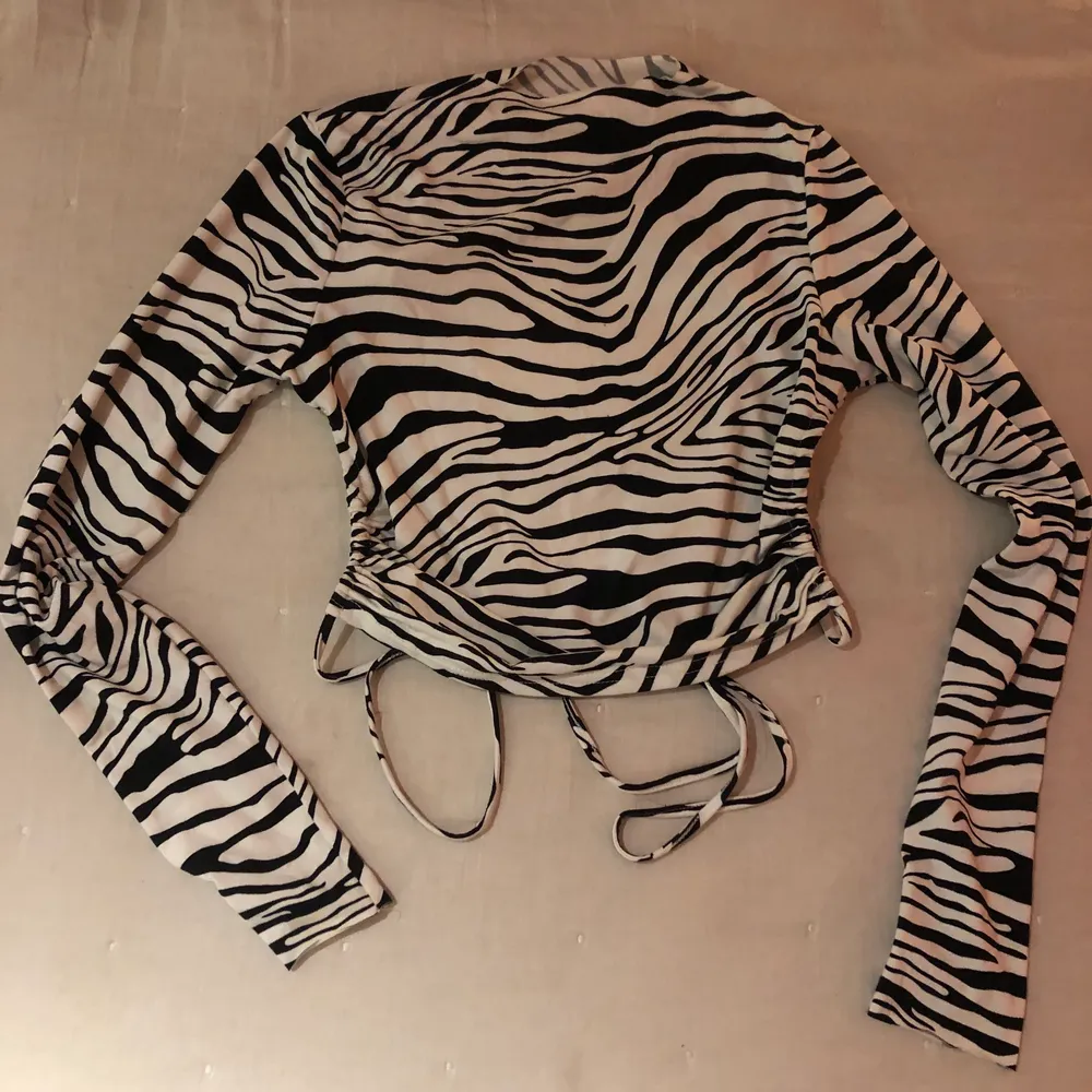 Långärmad tröja med svart&vitt zebramönster som knyts i ryggen! Är i storlek S men skulle säga att den passar allt från XS till en mindre M 💕 I superbra skick och väldigt skön kvalitet . Toppar.