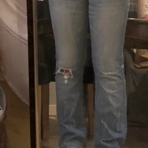 Lågmidjade jeans från Dr.Denim  - Lågmidjade jeans från Dr.Denim. Dem sitter bra och är för långa för mig, jag är 168. Dem har en knappgylf istället för dragkedja. Köpta second hand och säljer då den ej satt så som jag ville. Dem har en slitning på ena knät och så är det en tygbit under som är röd. 