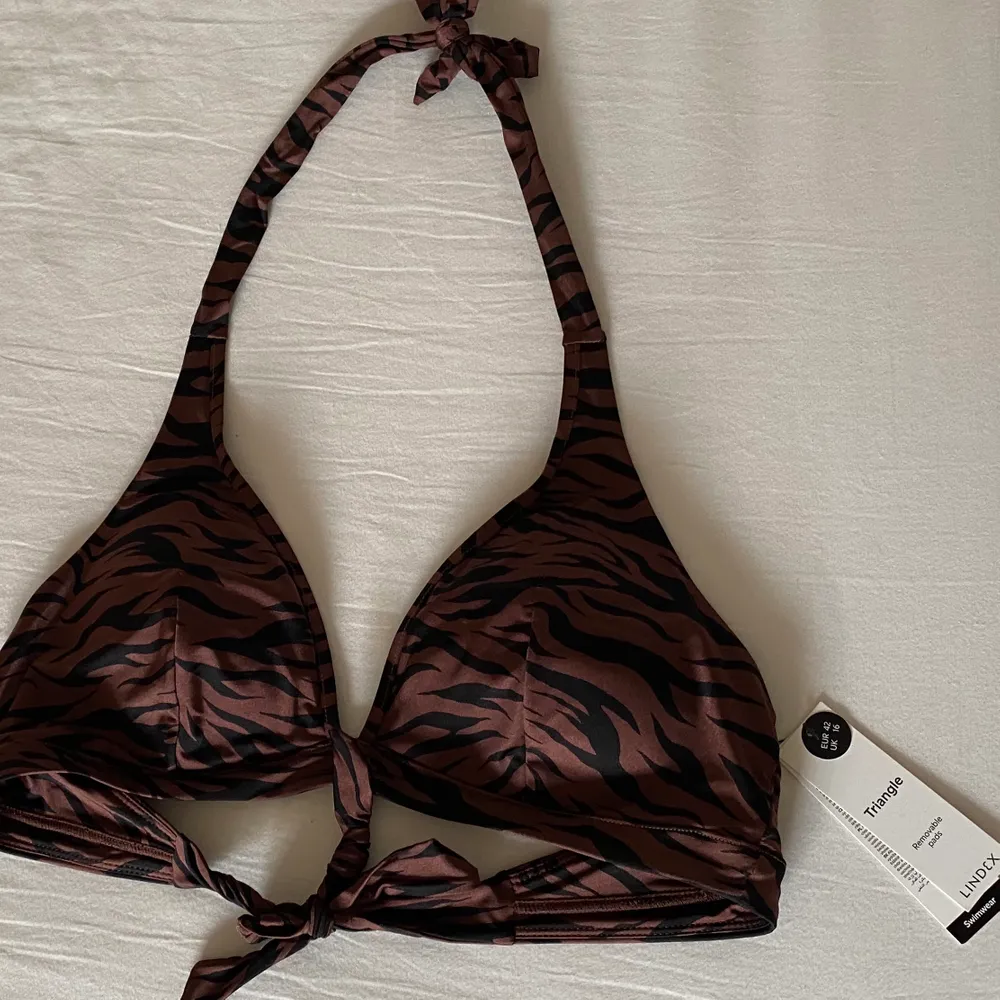 Brun bikiniöverdel med zebramönster från Lindex, storlek 42 (M-L). Den är justerbar så passar flera storlekar👍🏼 aldrig använd 🥰. Övrigt.
