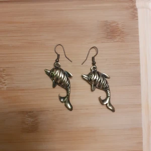 Skitfina delfin-örhängen  - Söta delfin-örhängen i okänd metall som inte är tunga alls. Enbart prövade ett par år tillbaka och kommer givetvis desinfekteras och göras rent. Fraķt på 12 kr tillkommer💖