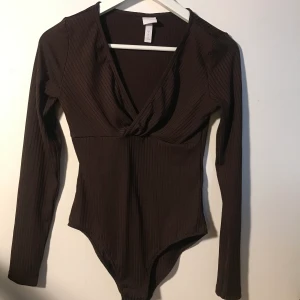 Brun body, Hm Trend  - En jättefin brun Body i ribbad silke-struktur från HM Trend!  Perfekt under både jeans och kostymbyxor. 