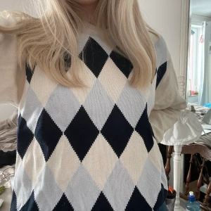 Argyle-mönstrad tröja - Jättesöt tröja med fina färger och en liten nalle puh på ärmen. Tyvärr kommer den inte till användning. Ljus fläck på vänster arm som knappt syns, annars gott skick!