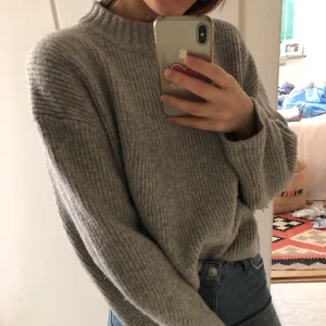 Stickad tröja - Kort stickad tröja i grått. En älsklingströja som jag säljer för att uppdatera garderoben lite. Supersskön och varm, lite noppig som syns på bild två men verkligen fin och passar till allt. Möts i Sthlm eller fraktar. Köparen står för frakt.