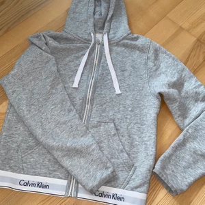Calvin Klein tjocktröja  - En väldigt snygg tight tjocktröja från Calvin Klein med zip. Så man kan använda den både uppknäppt och knäppt. I väldigt bra skick! ✨ storlek XS men passar även mig som har S. Bild nr 1 är utan blixt som visar en mer rättvis färg och bild nr 2 är med blixt. 