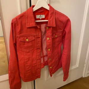 Röd jeansjacka - Röd jeansjacka köpt på second hand. Säljes pga har för många jackor. Lite mer hallonröd än starkröd. Knappars är guldfärgade. Stretchigt material! 