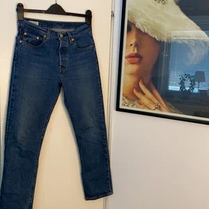 Levis Jeans  - Riktigt snygga blåa Levis 501. Har använts men ser nästan helt nya ut, skick 10/10. Storlek: Midja-25 Längd-28 (dam) men kan även användas för killar. Dragkedjan på jeansen ersätts istället med knappar men det syns ändå inte! Köparen står för frakt. Köpt från Levis bestulen för 1100kr