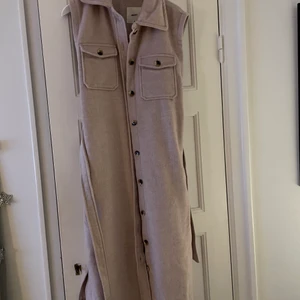 Lång väst, som ny,endast använd 2-3 ggr  - Lång beige väst med skärp i midjan. Som ny. Endast använd 2-3 ggr. Märke Object från Vero Moda. Storlek 40. 