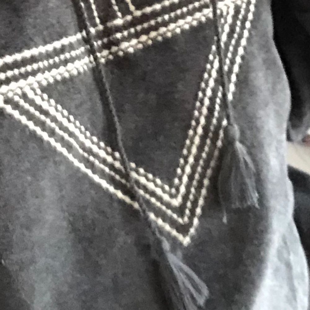 Gray thin sweater with ethnic patter and hood. Soft fabric similar to velvet. It has two strings hanging from the hood with a pompom at the end. It is loose or baggy.. Huvtröjor & Träningströjor.