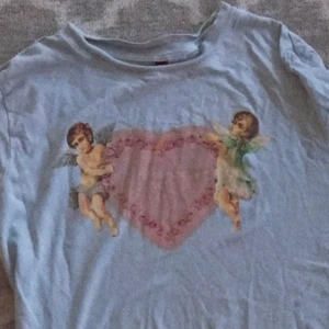 T-shirt  - En blå T-shirt med änglar på! ‼️ Andvänt en gång‼️ 25kr + 24kr frakt = 49kr totalt! ❗️priser kan diskuteras❗️